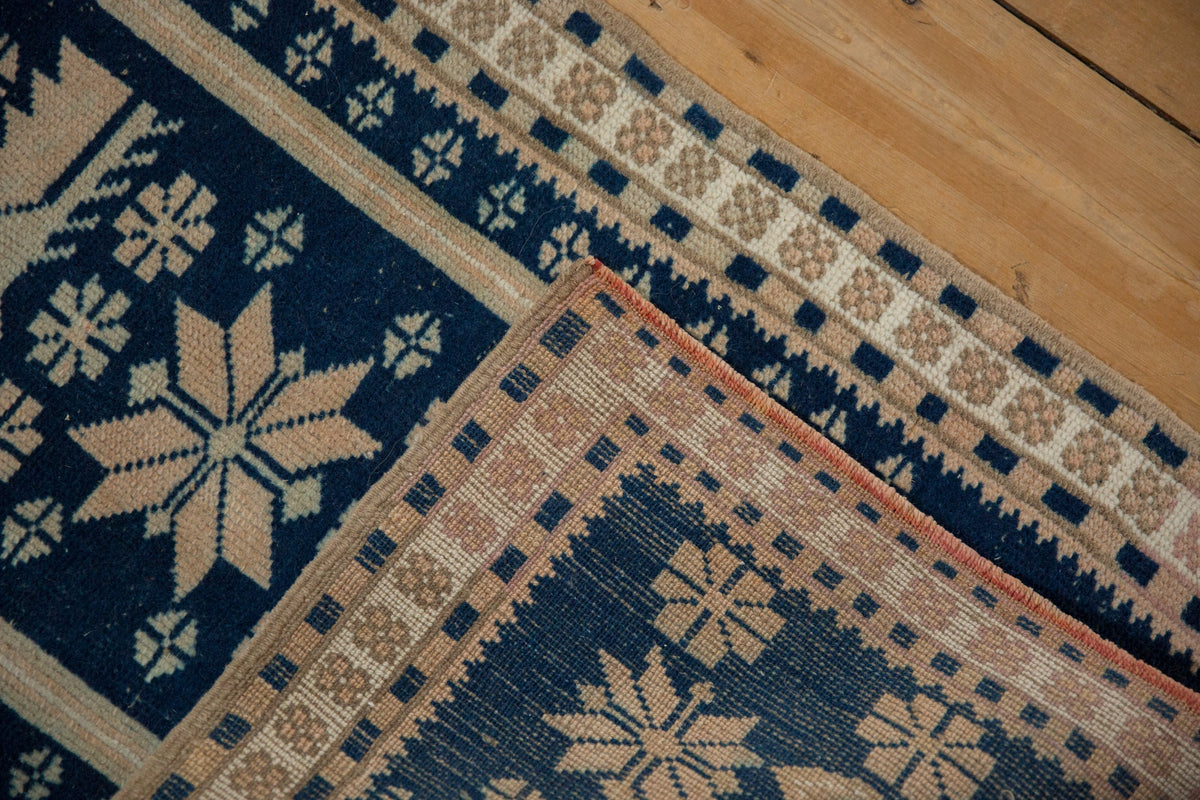 Close-up of a patterned rug with geometric designs on a wooden floor.