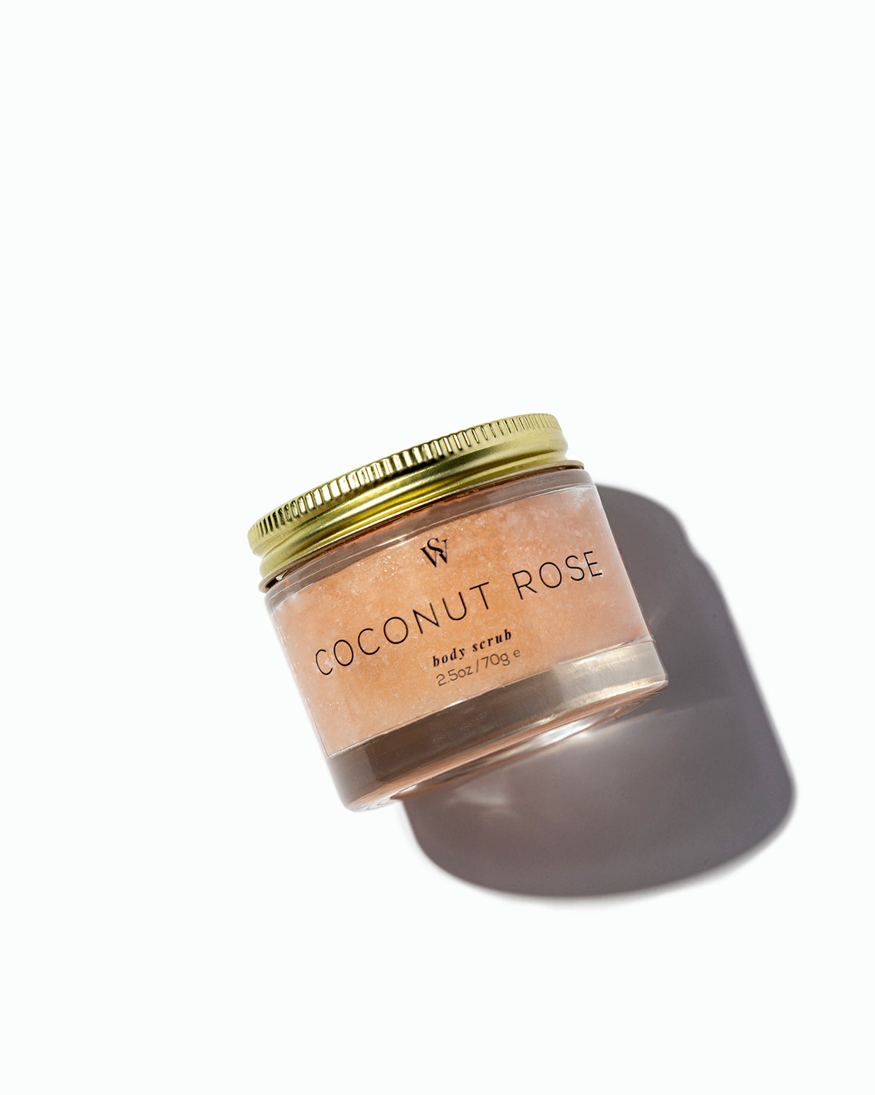 Jar of coconut rose body scrub with a gold lid on a white background
