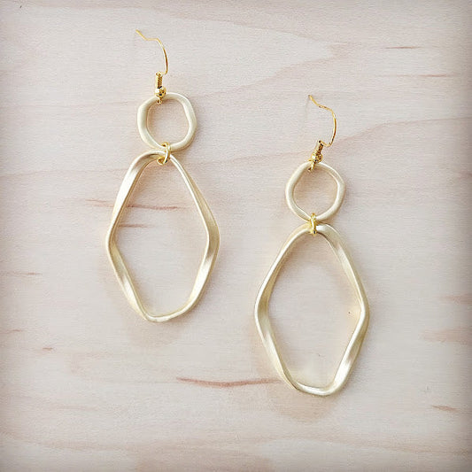 Gold hoop earrings on a light wooden surface