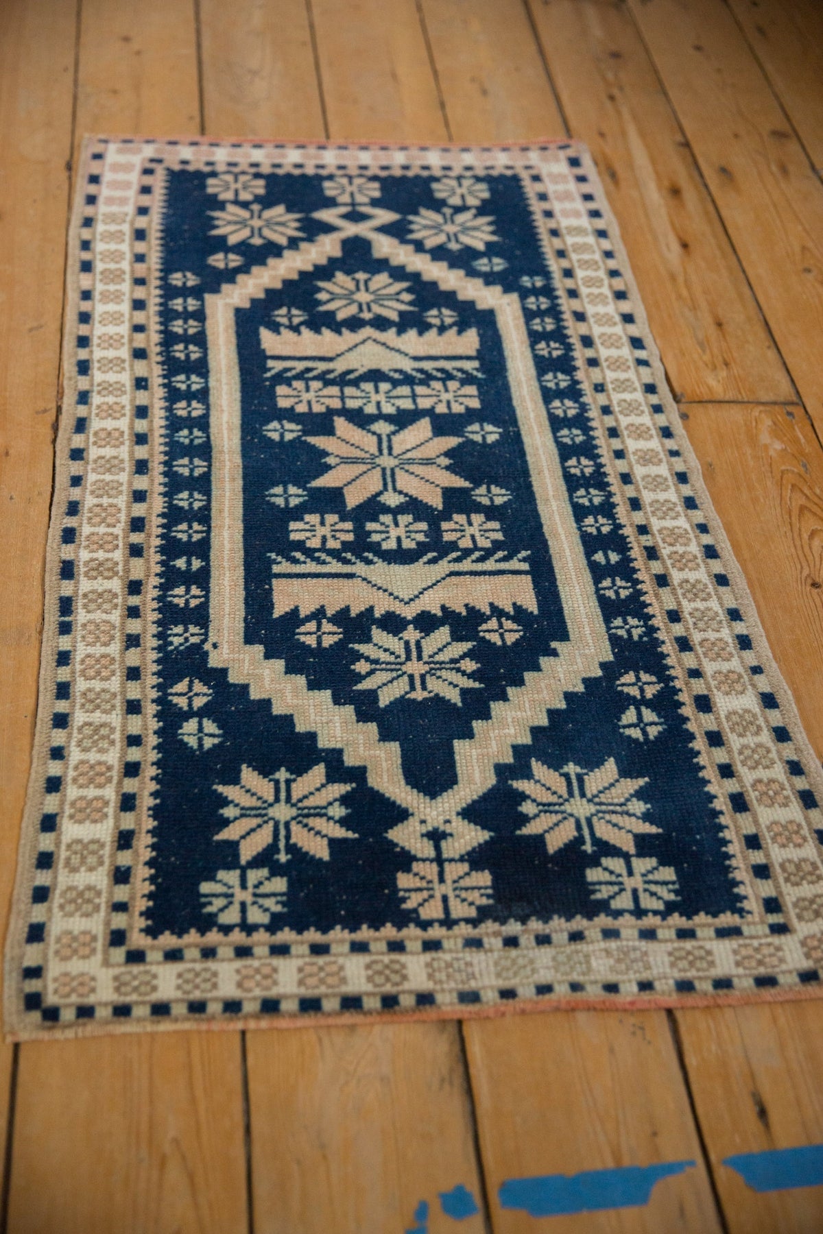 Decorative rug with blue and beige pattern on a wooden floor