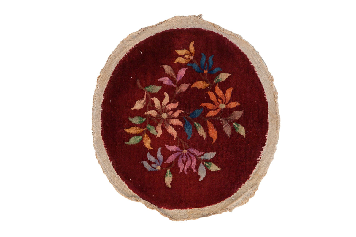 Round embroidered rug with floral patterns on a white background