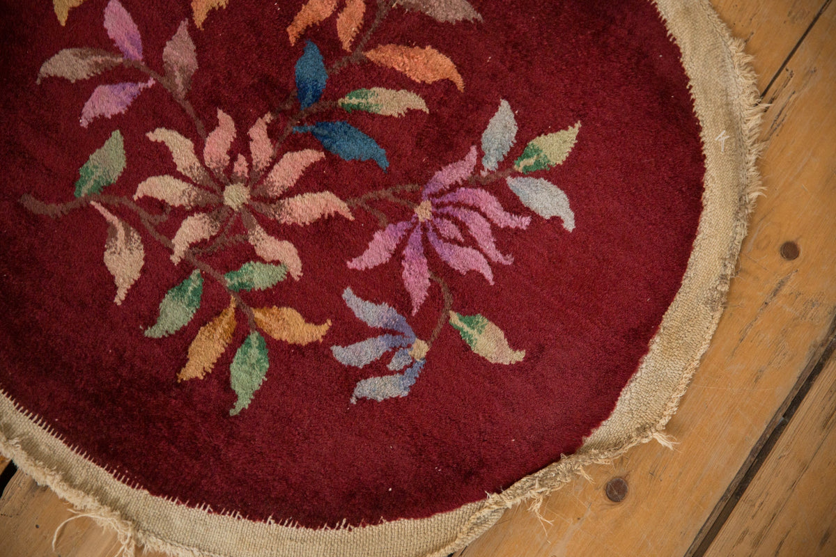 Round embroidered rug with floral patterns on a wooden floor
