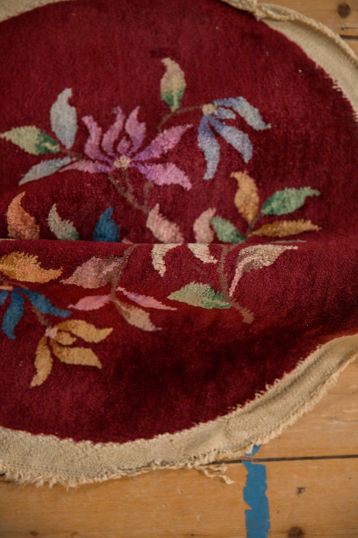 Close-up of a red embroidered fabric with floral patterns on a wooden surface