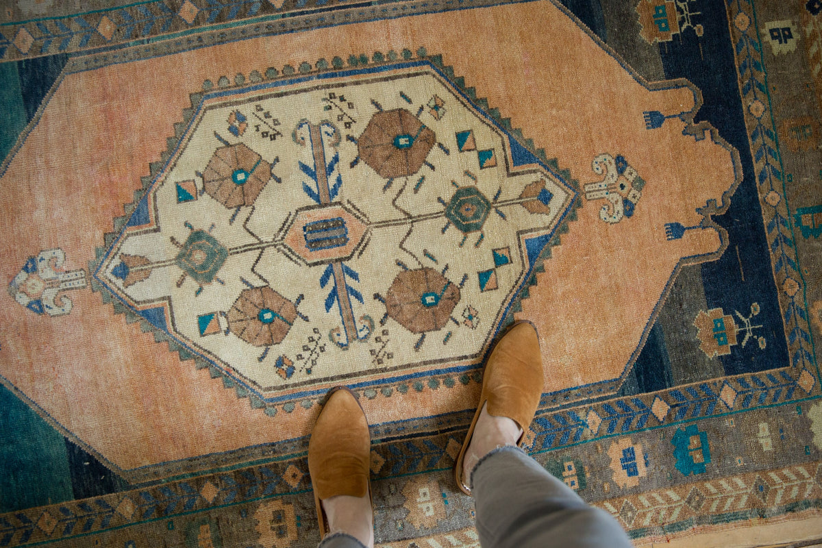 Person wearing brown shoes on a patterned rug