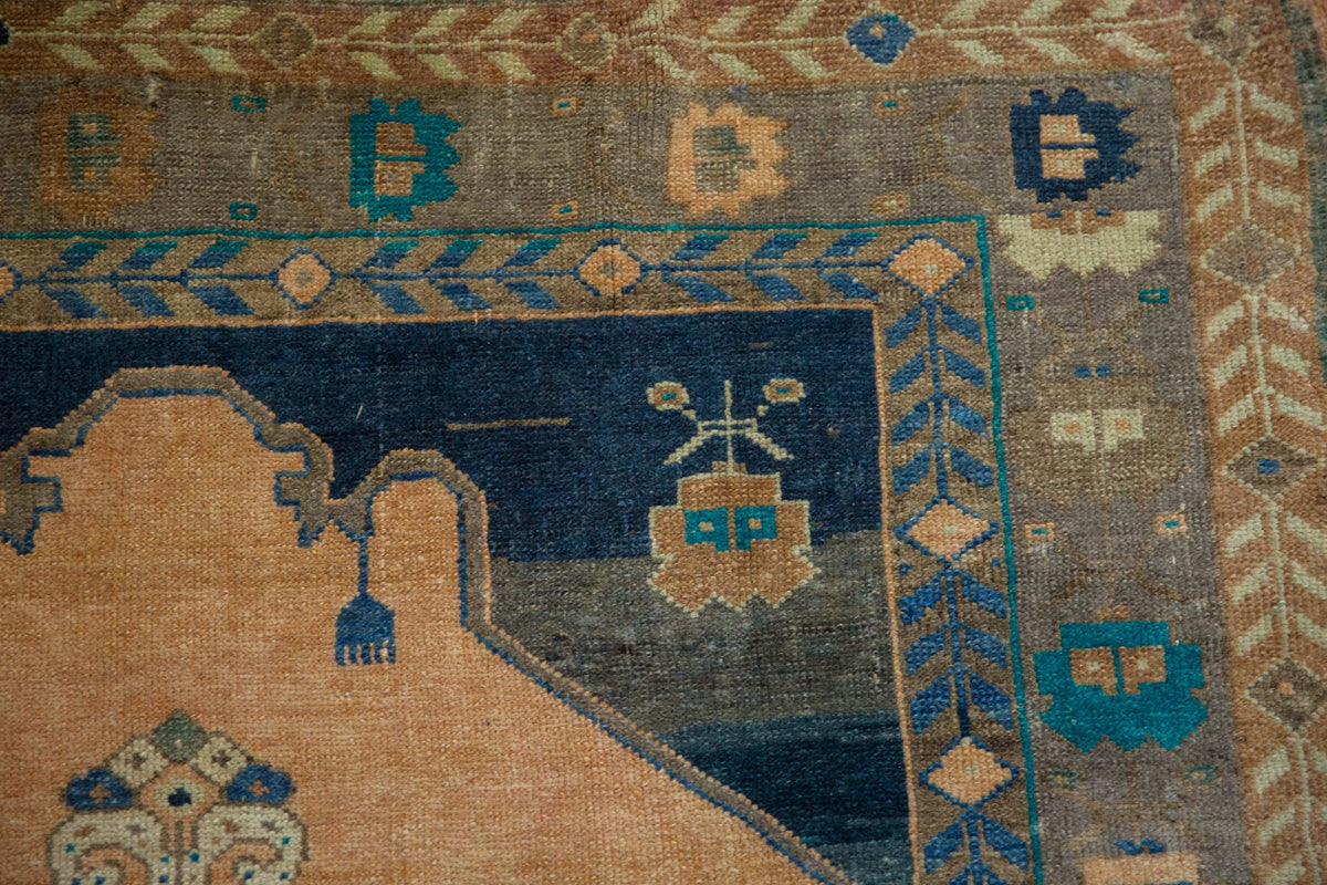 Close-up of a patterned rug with geometric designs in blue, brown, and beige.