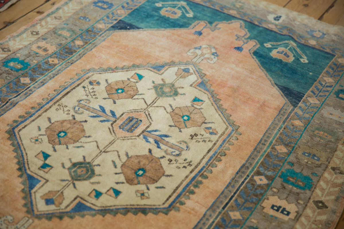Close-up of an ornate rug with geometric patterns on a wooden floor.