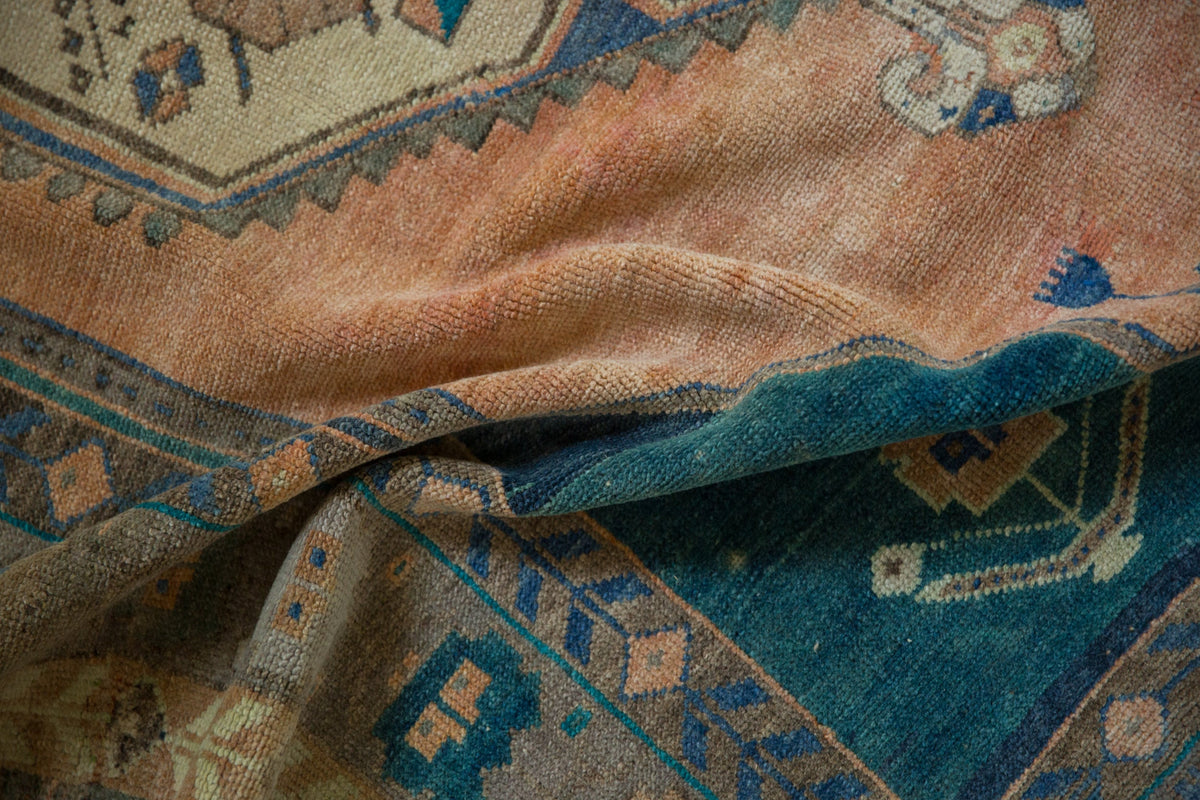 Close-up of an intricately patterned rug with blue and brown colors.