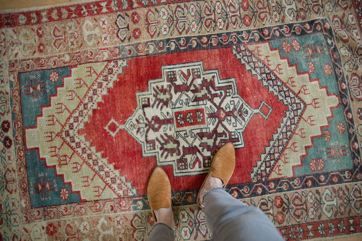 Person wearing brown shoes stepping onto a patterned rug