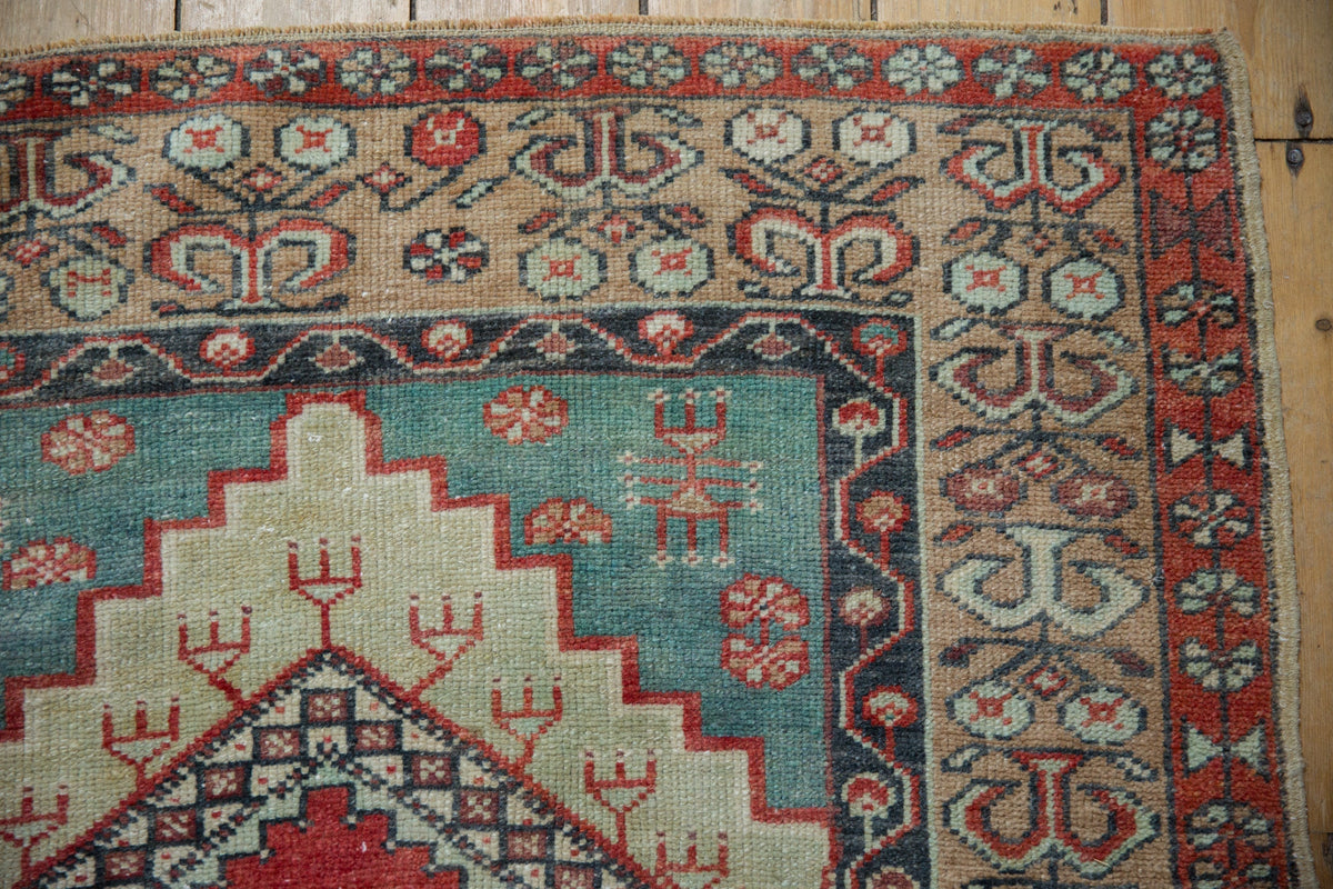 Close-up of a patterned rug with intricate designs on a wooden floor.
