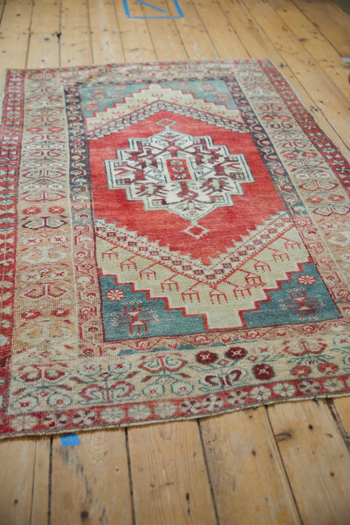 Vintage rug with intricate patterns on a wooden floor