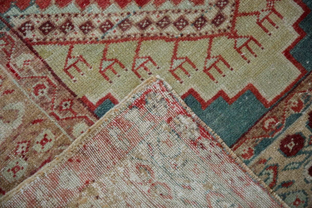 Close-up of patterned rugs with geometric designs in red, beige, and blue.
