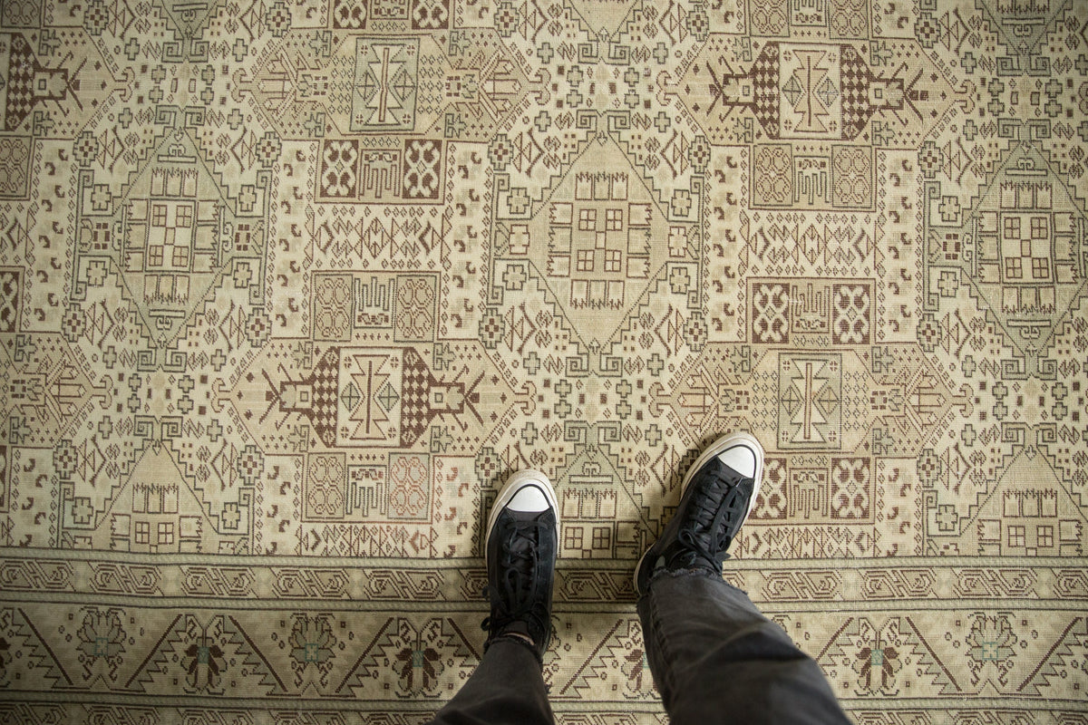 Person wearing black shoes on a patterned carpet