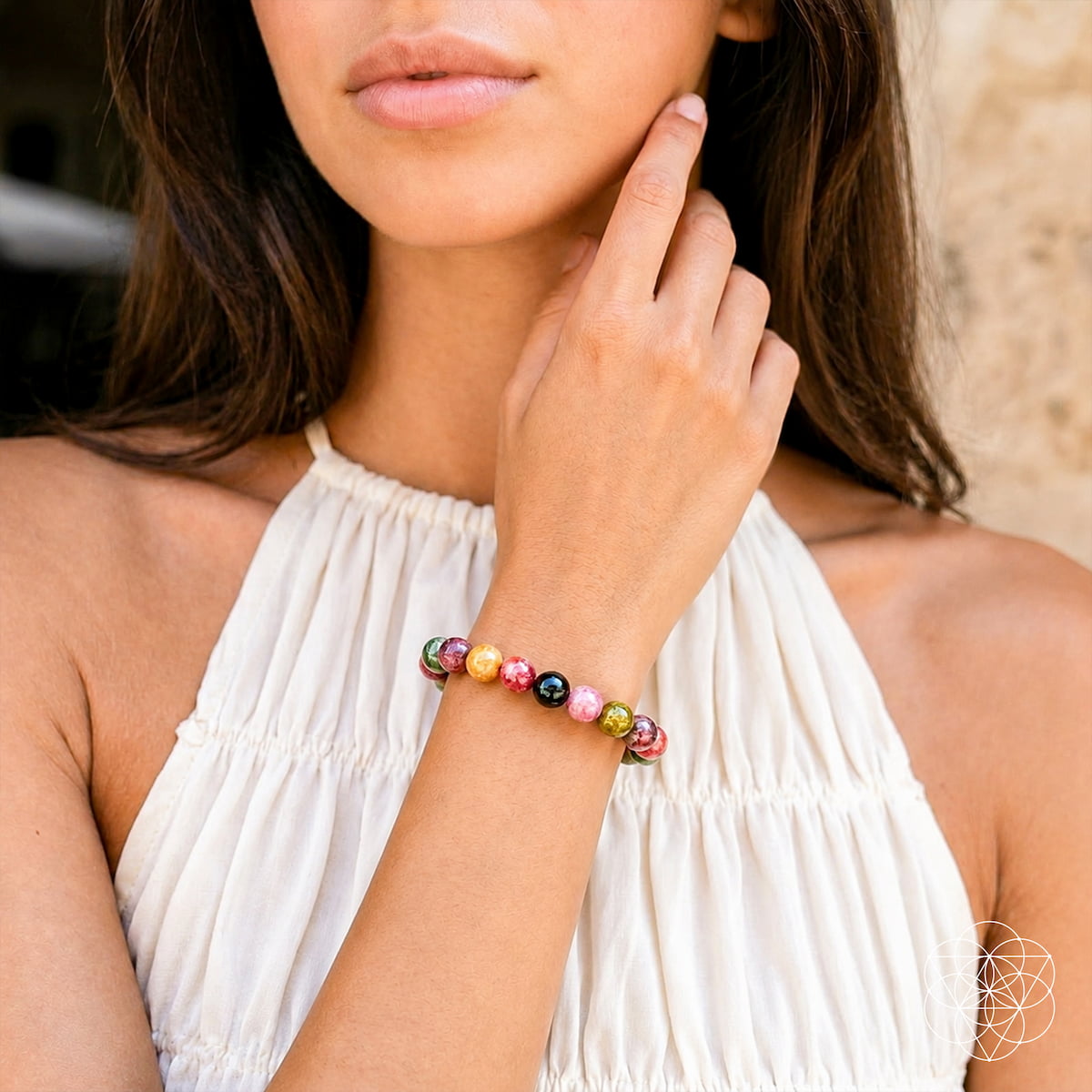 Woman wearing a colorful beaded bracelet on a blurred background