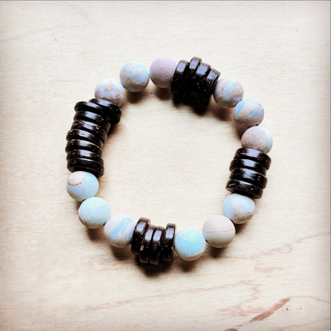 Bracelet with alternating dark and light beads on a wooden surface