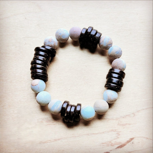 Bracelet with alternating dark and light beads on a wooden surface
