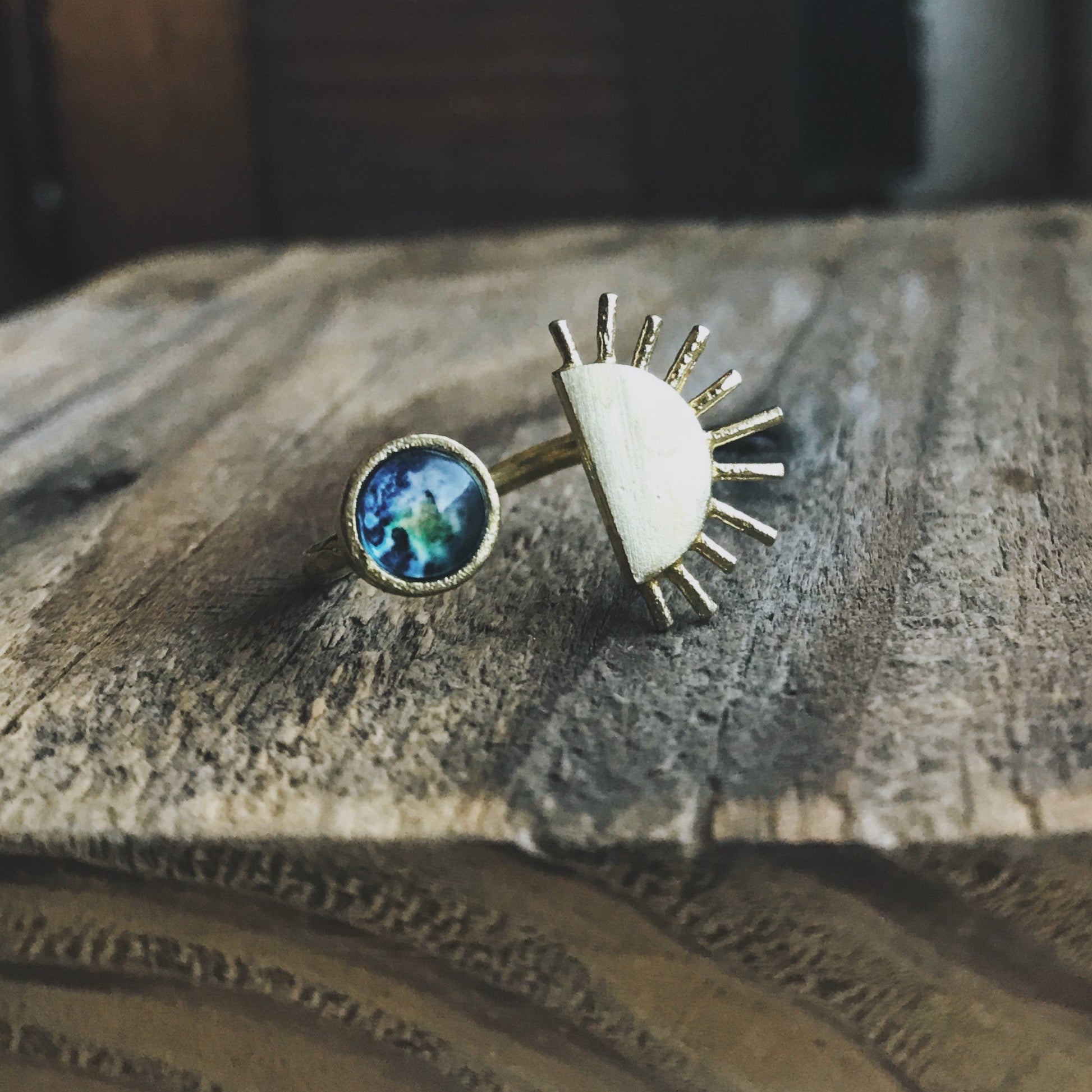 Two rings with different designs on a wooden surface