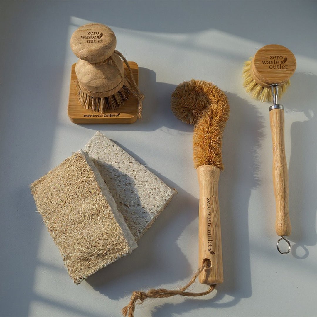 Set of zero waste cleaning tools including brushes and a sponge on a light background
