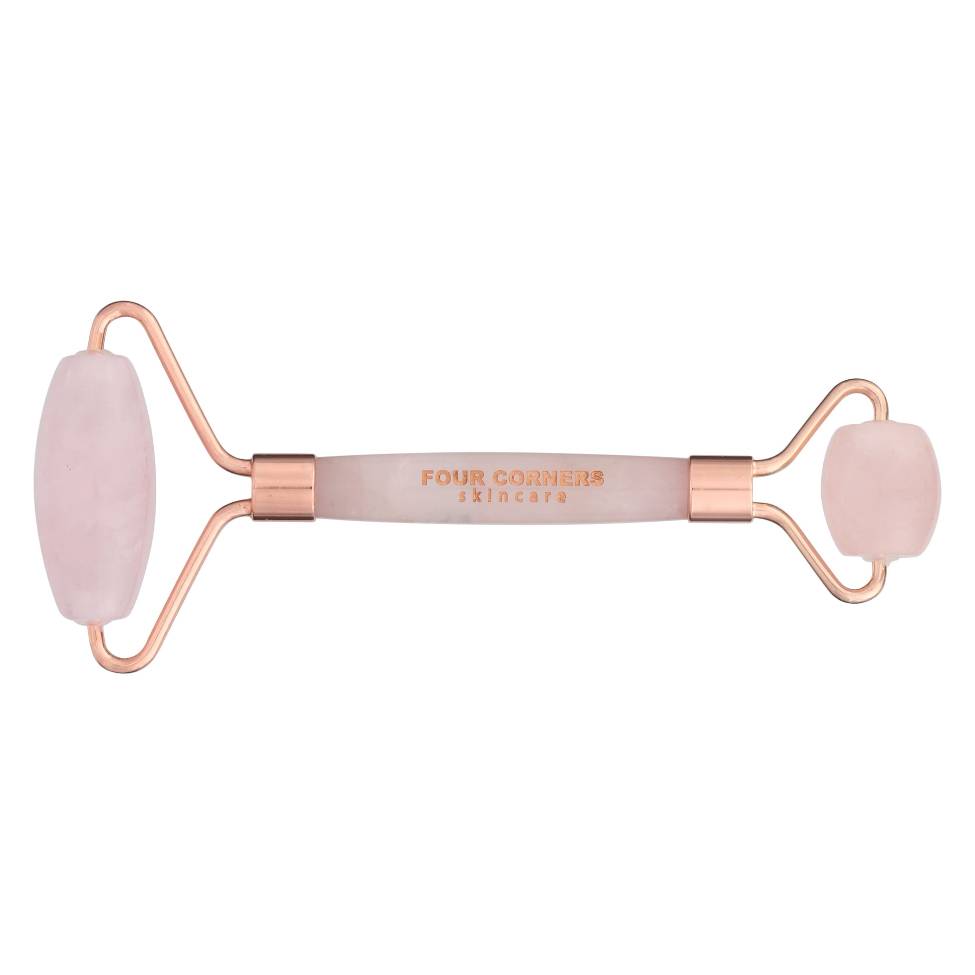 A two-sided rose quartz face roller with rose gold accents and 'Four Corners' branding in the center.