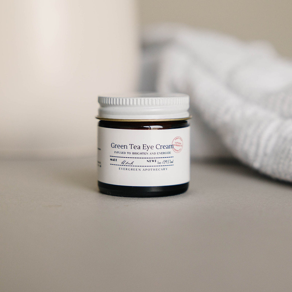 Jar of Green Tea Eye Cream on a neutral background