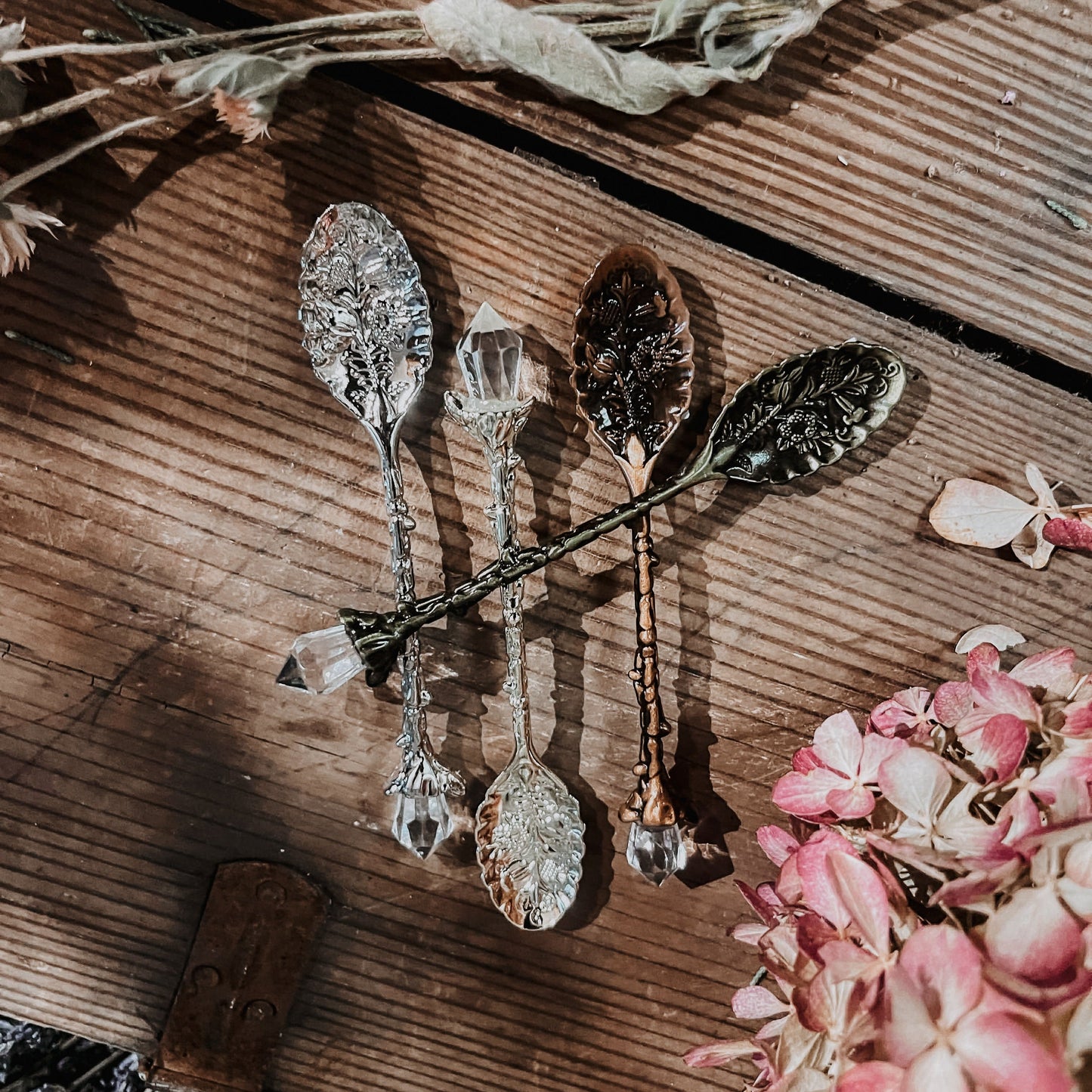 Decorative spoons on a wooden surface with flowers