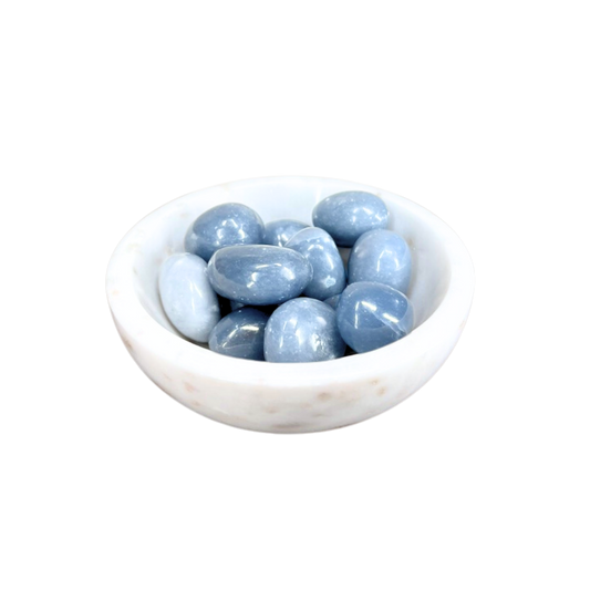White bowl filled with light blue stones on a white background