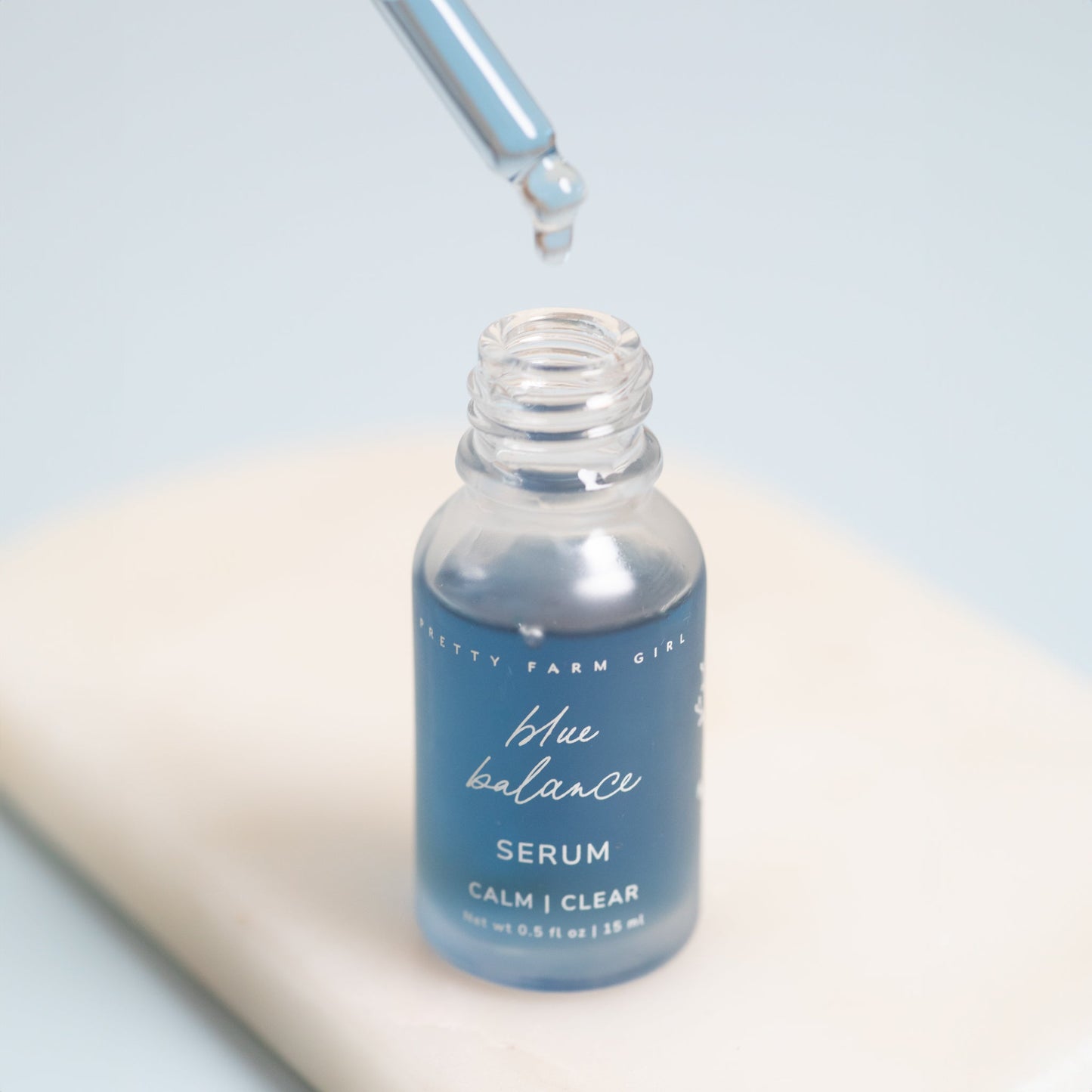 Blue bottle of serum with dropper on a light background