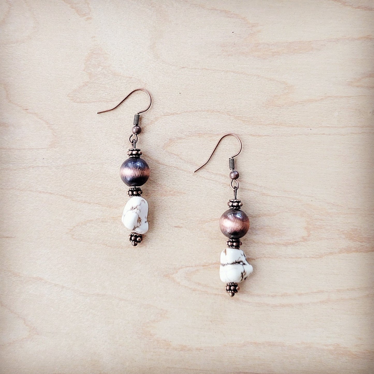 Pair of earrings with beads on a wooden surface