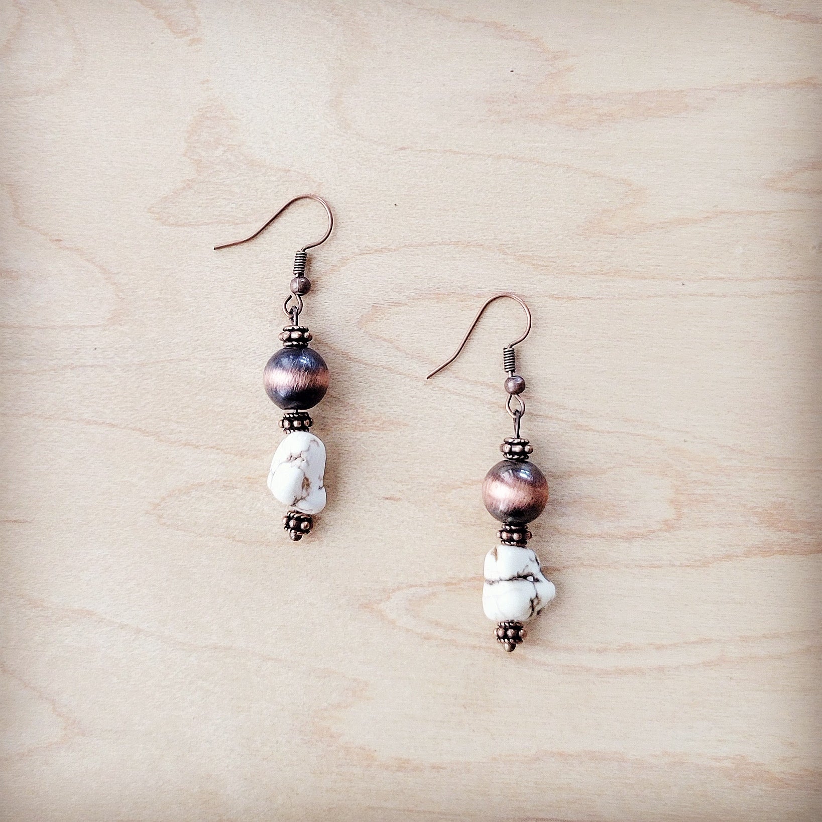 Pair of earrings with beads on a wooden surface