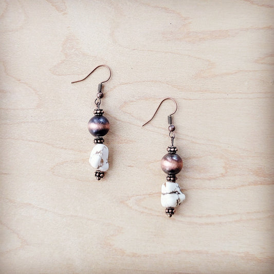 Pair of earrings with beads on a wooden surface