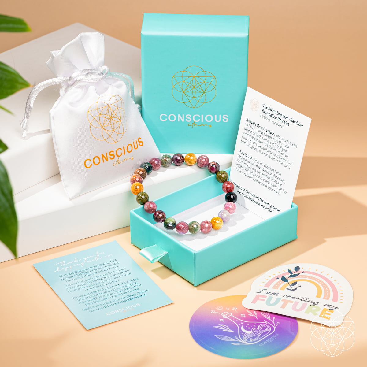 Colorful beaded bracelet in a turquoise box with 'Conscious' branding, accompanied by cards and a coaster.