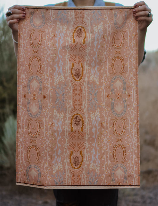 Person holding a large piece of patterned fabric with intricate designs.