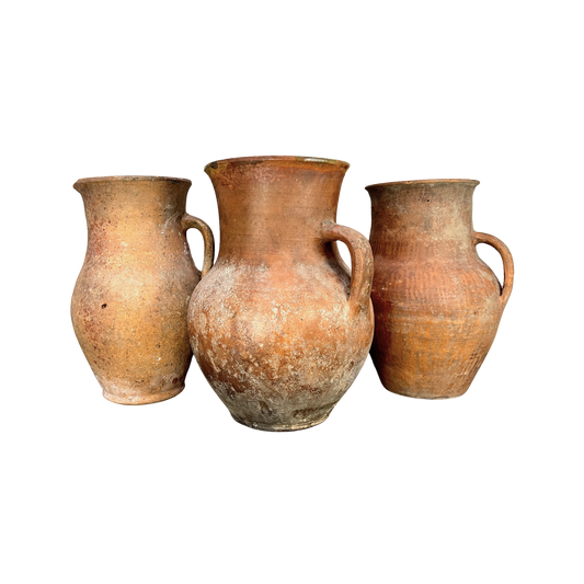 Three terracotta pots of varying sizes on a white background