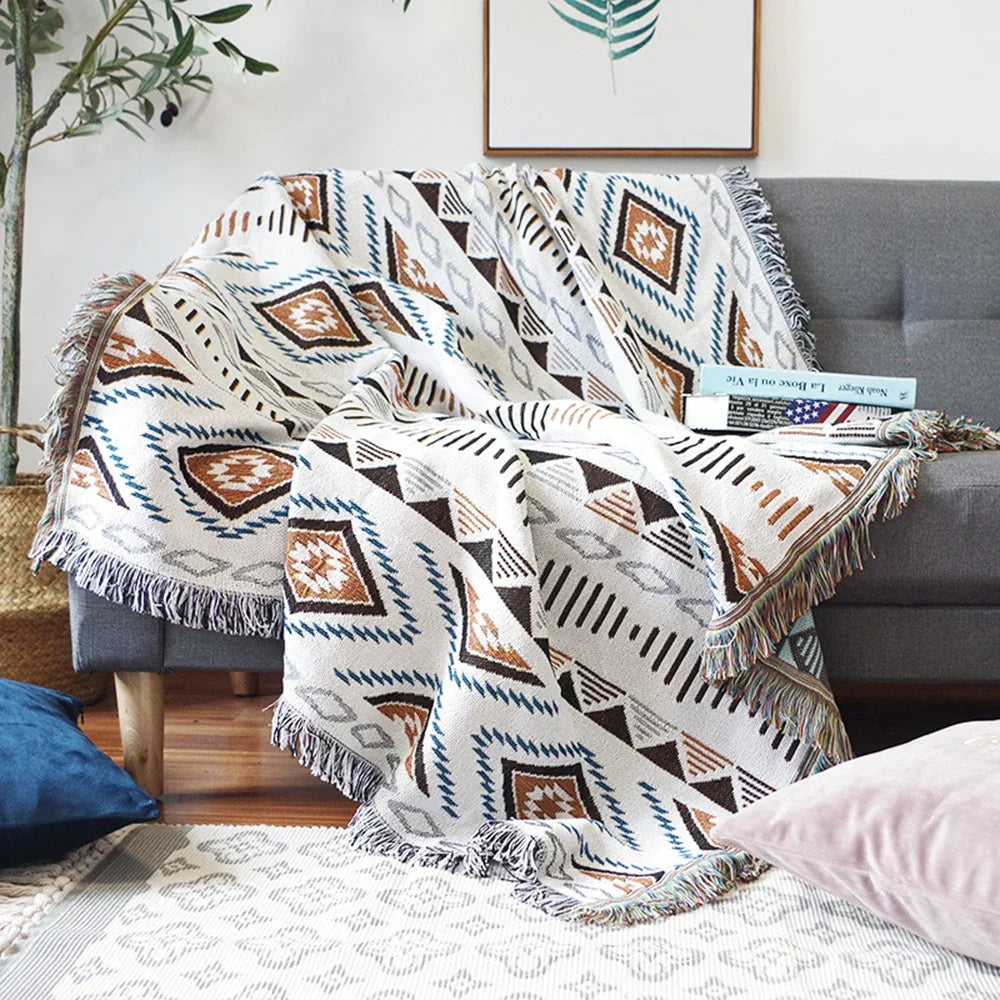 Gray armchair with a patterned blanket draped over it in a living room setting.