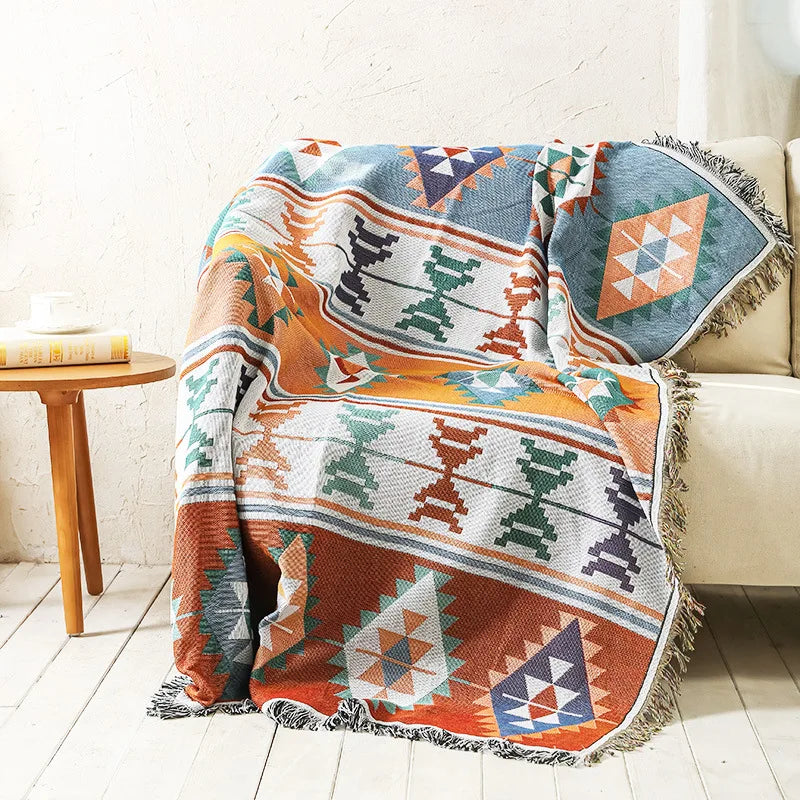 Colorful patterned blanket draped over a couch in a living room setting.