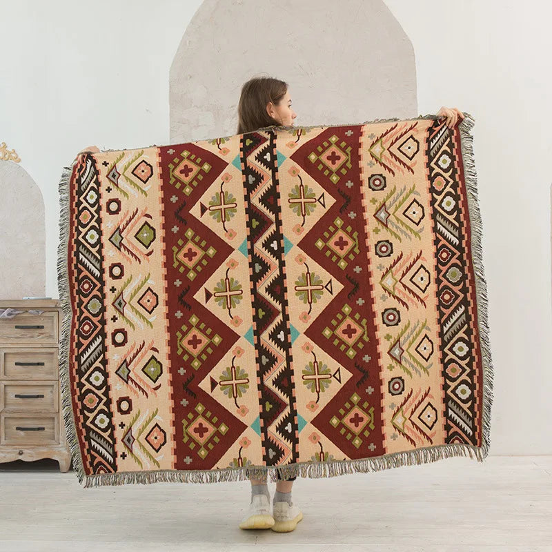 Person holding a patterned blanket in a minimalistic room