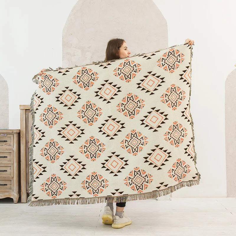 Person holding a patterned blanket in a minimalistic room