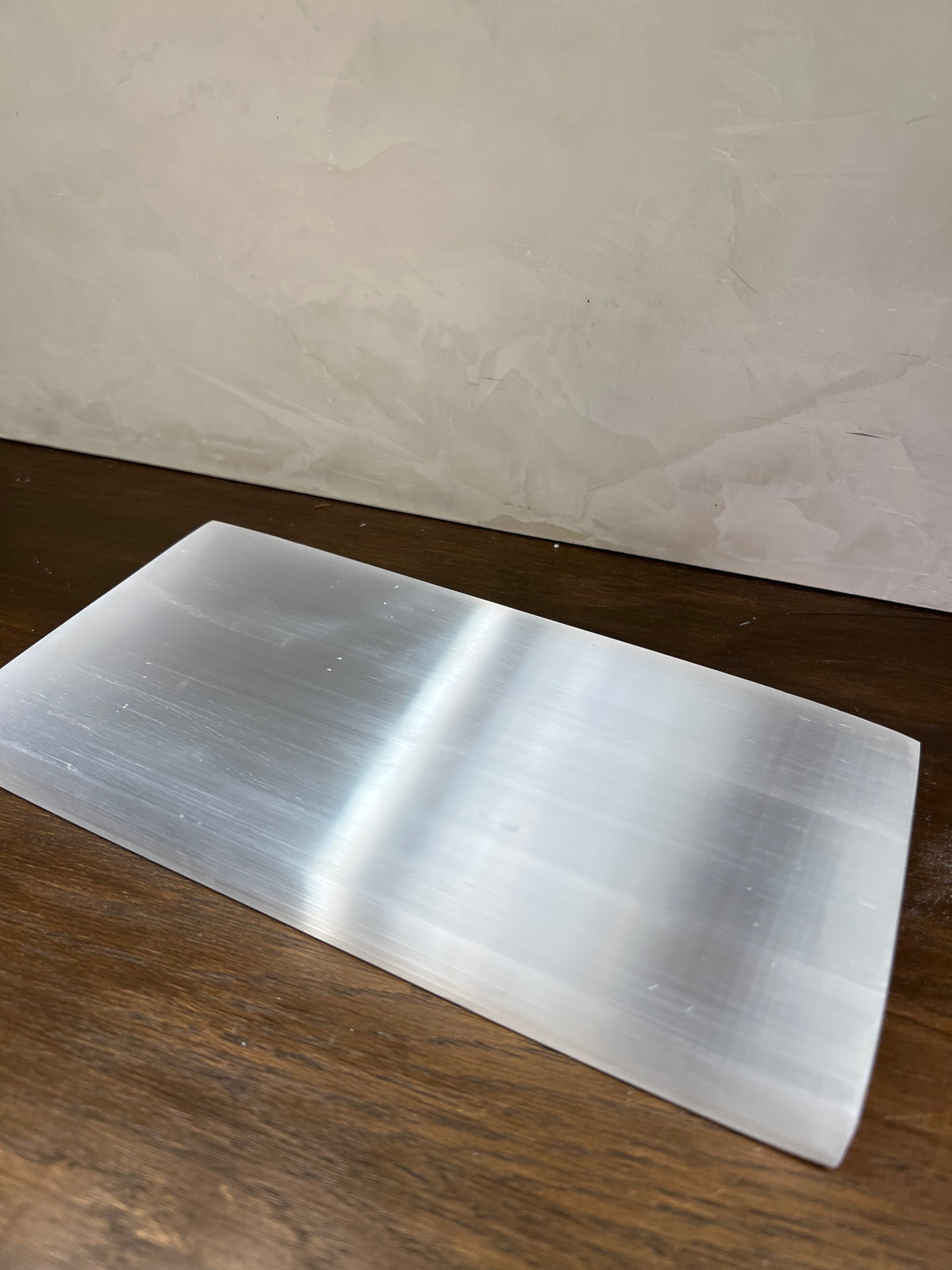 Selenite sheet on a wooden surface with a neutral background