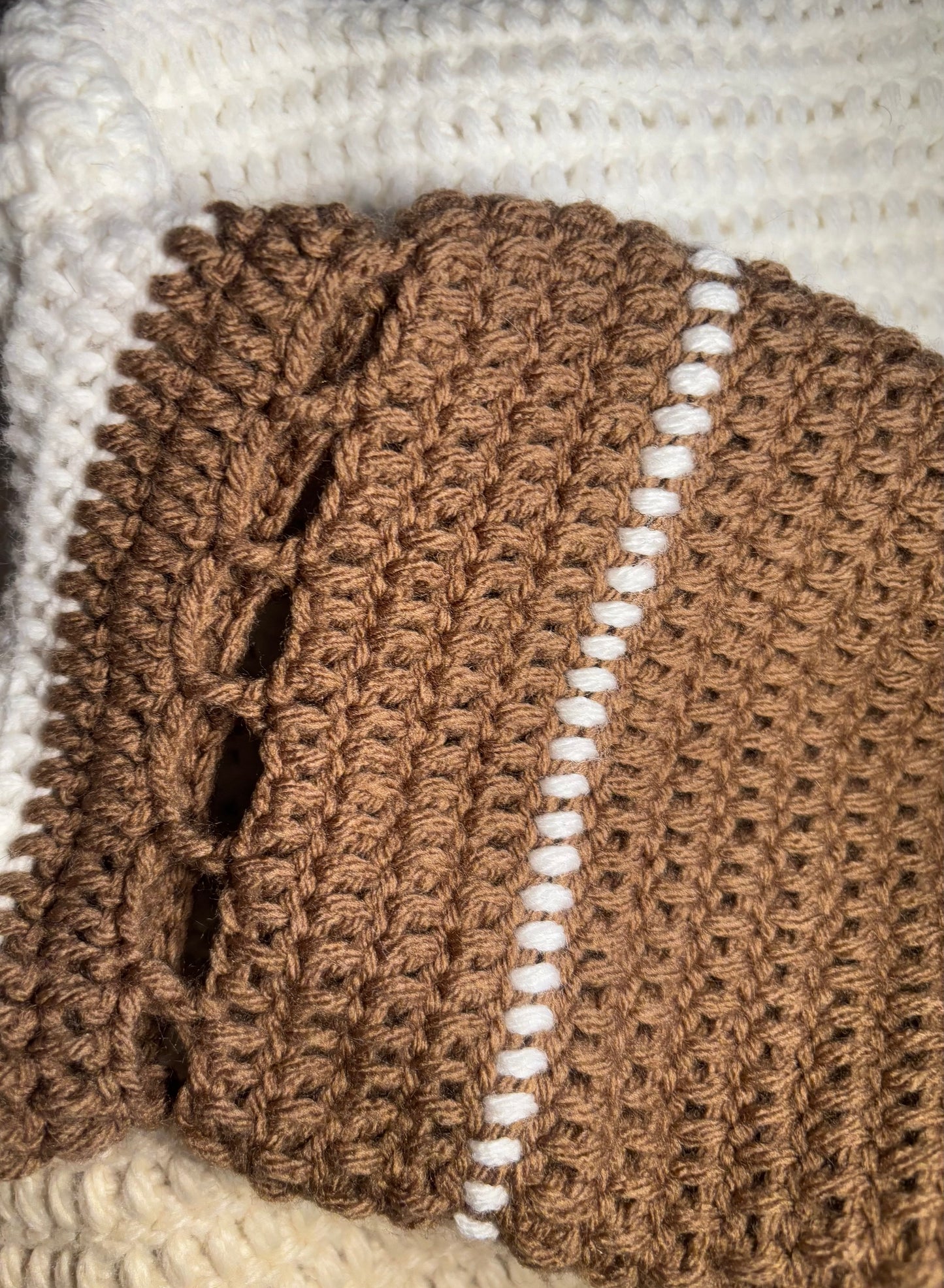 A color-block sweater laying flat. the neckline begins with white, then turns to beige, then brown on the body of the sweater. The sleeves descend from brown to beige to white. 