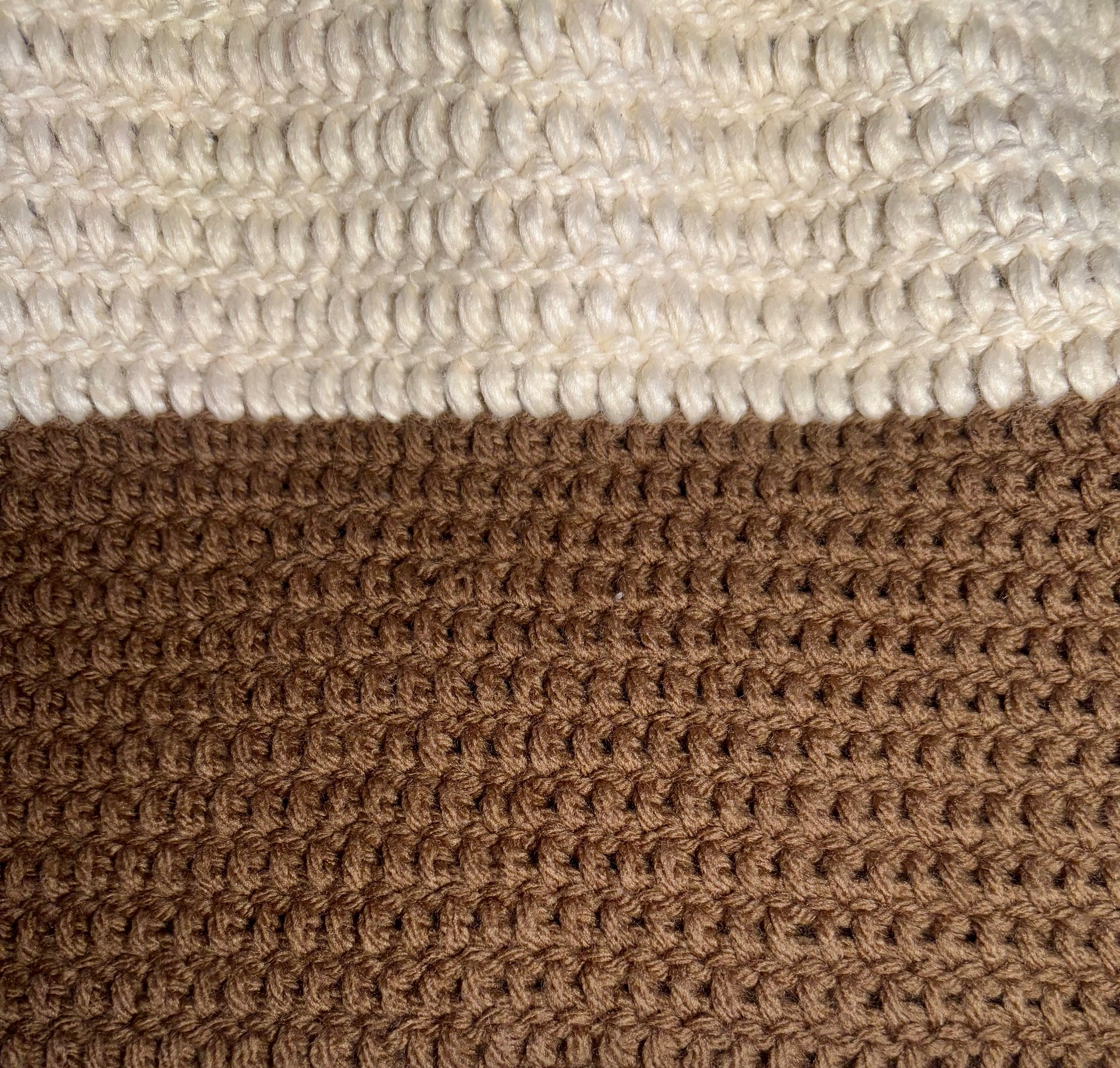 A color-block sweater laying flat. the neckline begins with white, then turns to beige, then brown on the body of the sweater. The sleeves descend from brown to beige to white. 