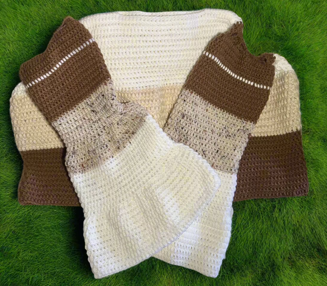 A color-block sweater laying flat. the neckline begins with white, then turns to beige, then brown on the body of the sweater. The sleeves descend from brown to beige to white. 