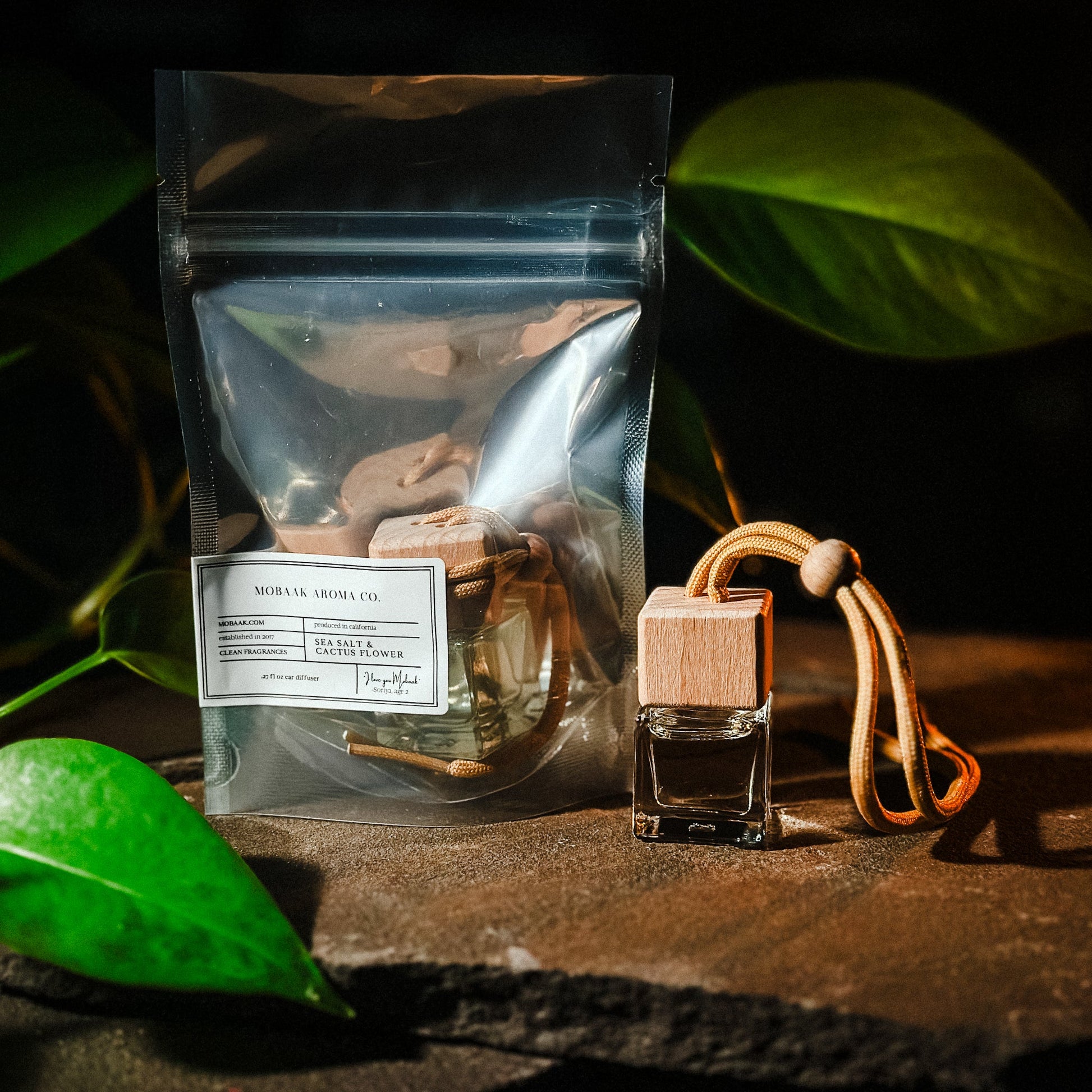 Tea package and car air freshener with green leaves in the background