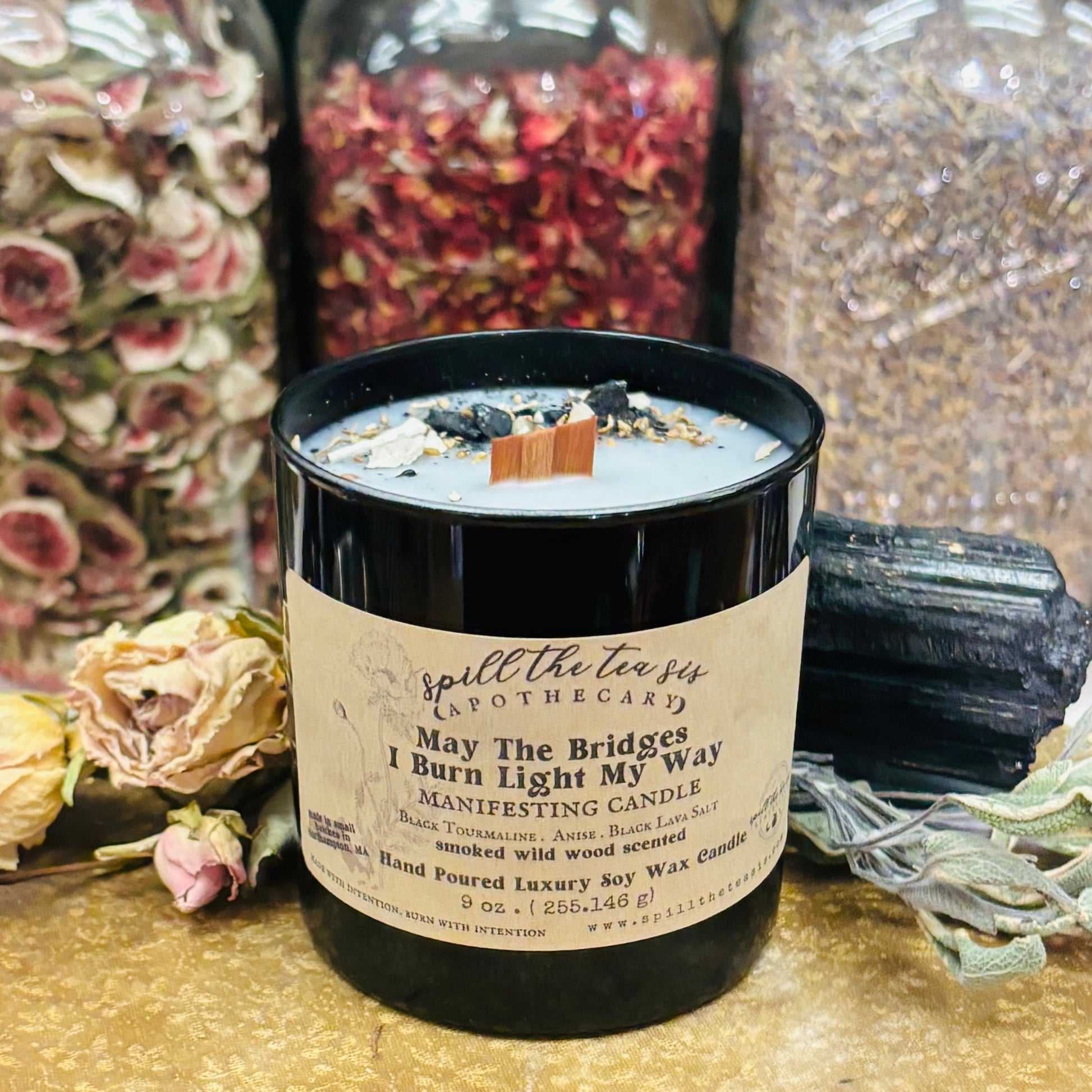 Candle with a label in front of decorative jars and crystals