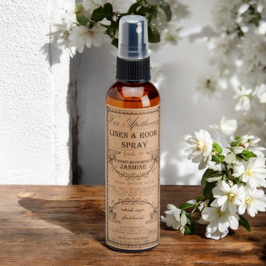 Linen & Room Spray bottle with floral label on a wooden surface with flowers in the background