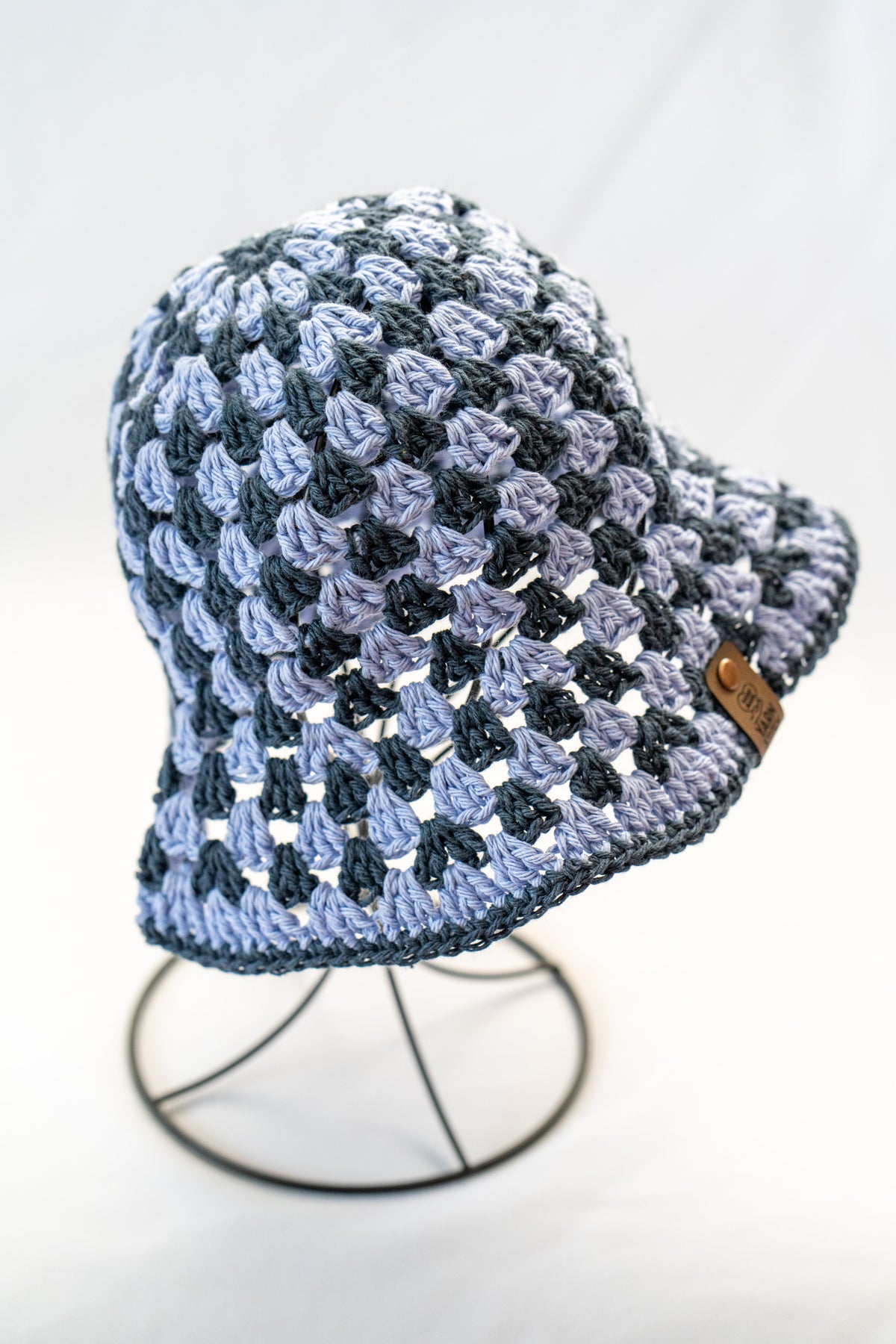 Blue and light blue checkered crochet hat on a white background