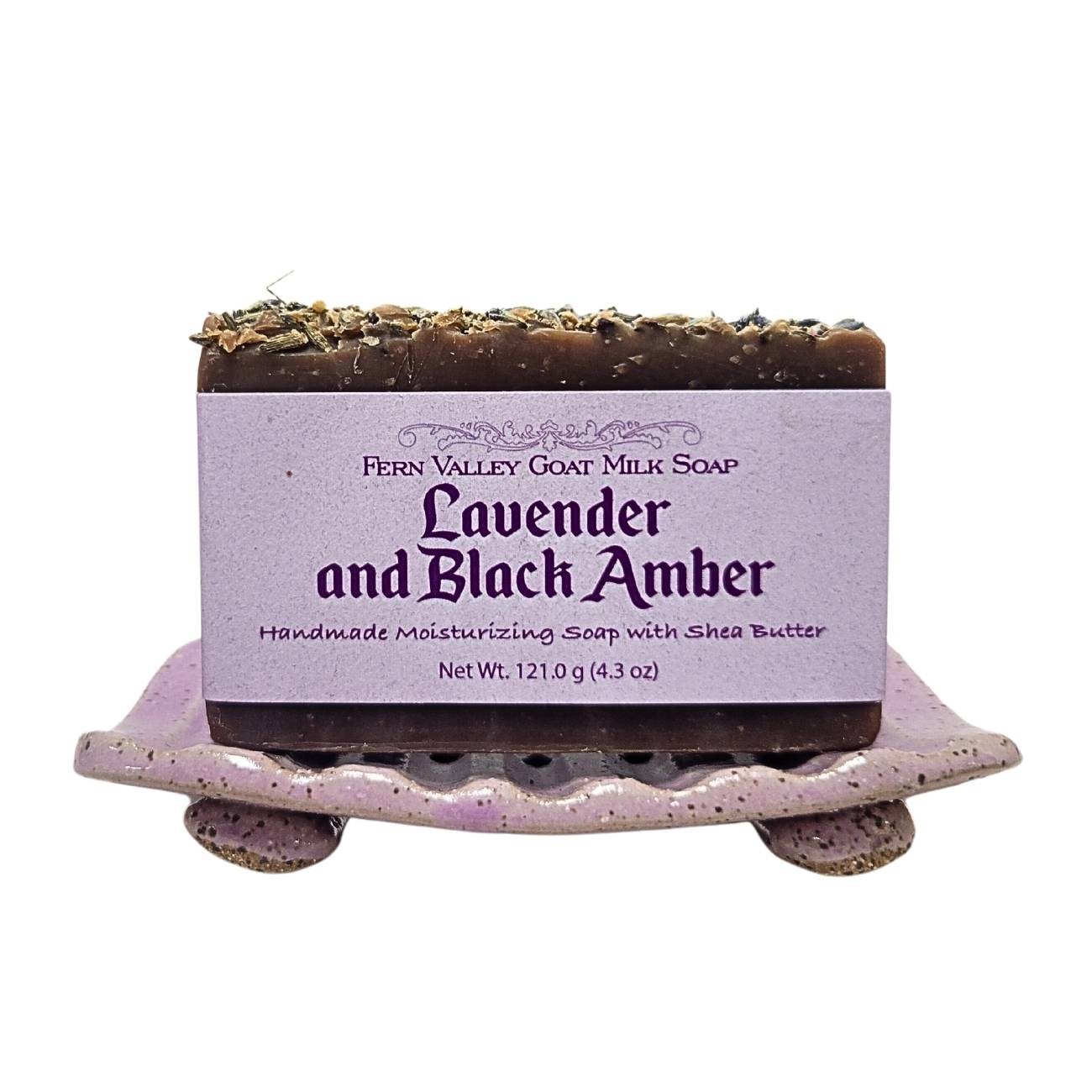 Bar of soap with lavender and black amber scent on a decorative soap dish.