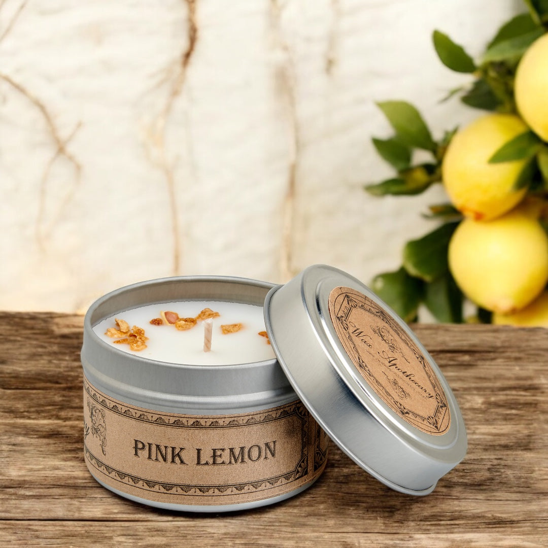 Pink Lemon scented candle in a tin with lemons in the background