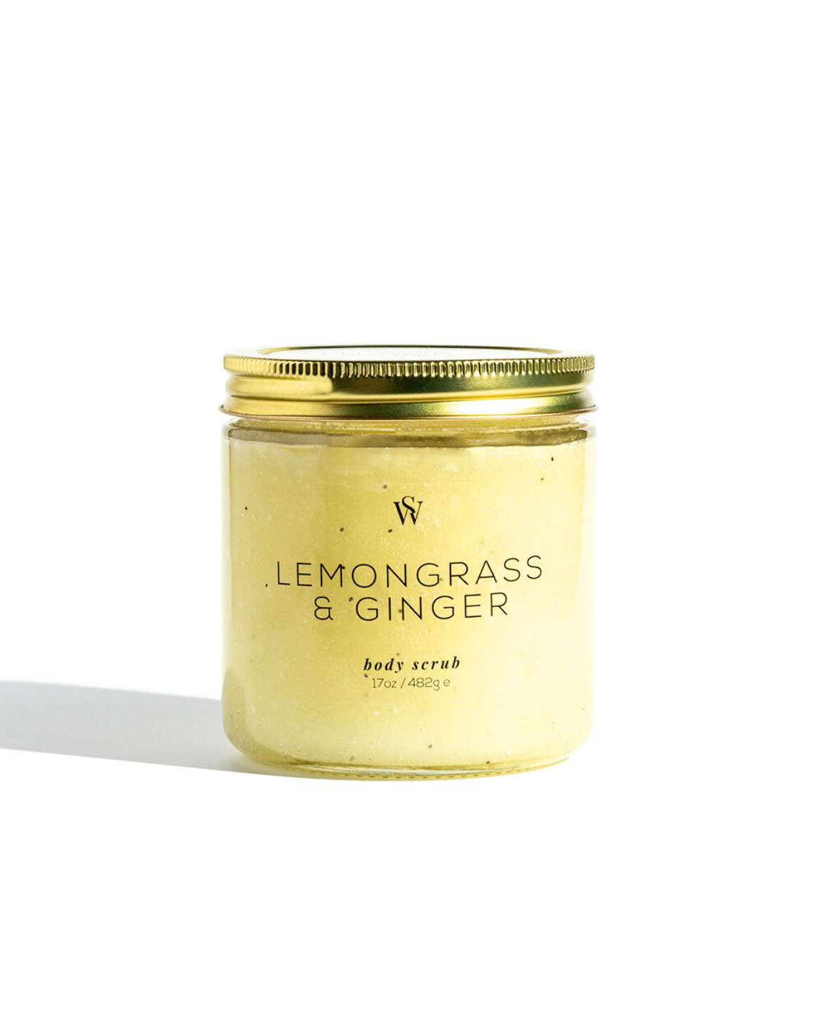 Jar of lemongrass and ginger body scrub with a gold lid on a white background