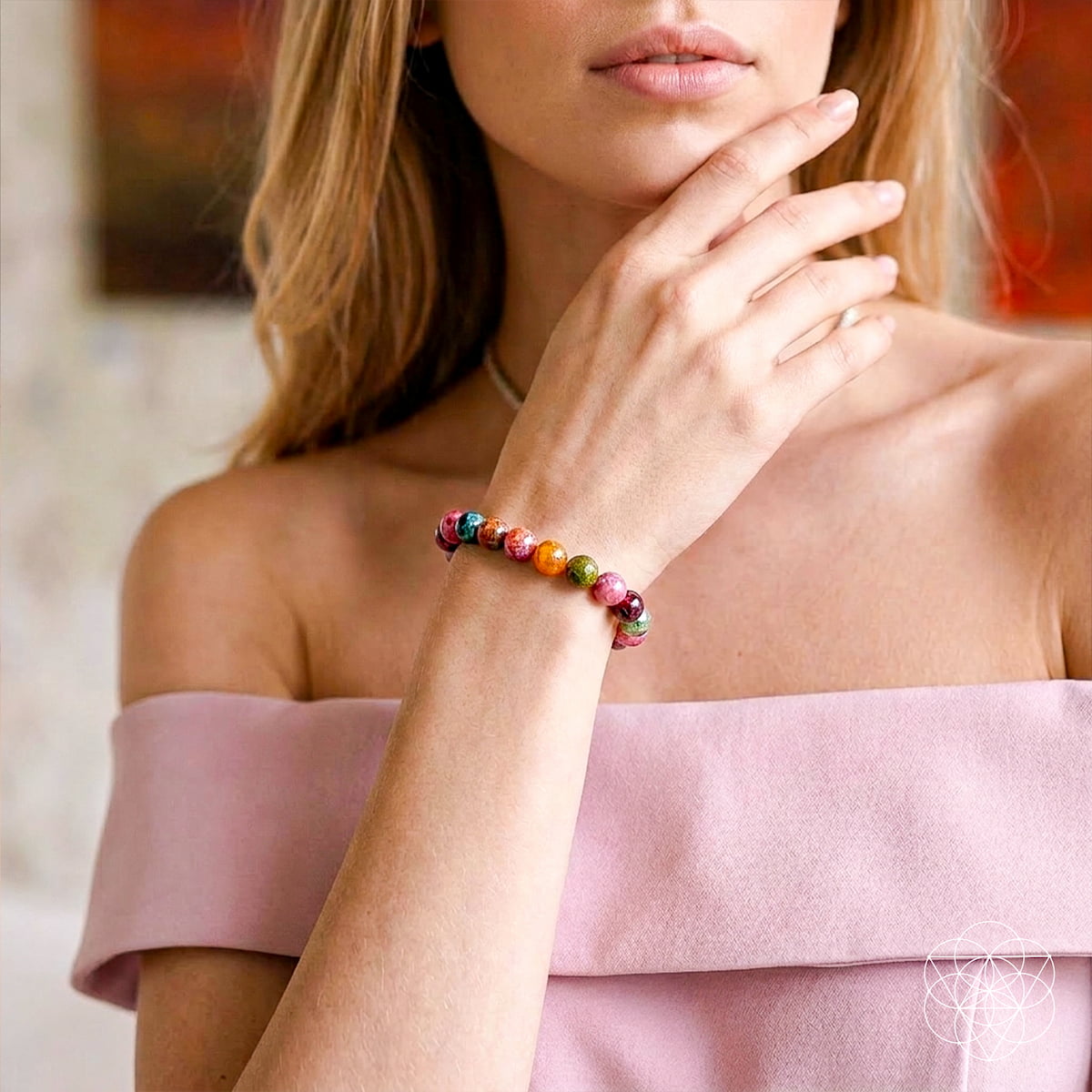 Woman wearing a colorful beaded bracelet on a blurred background