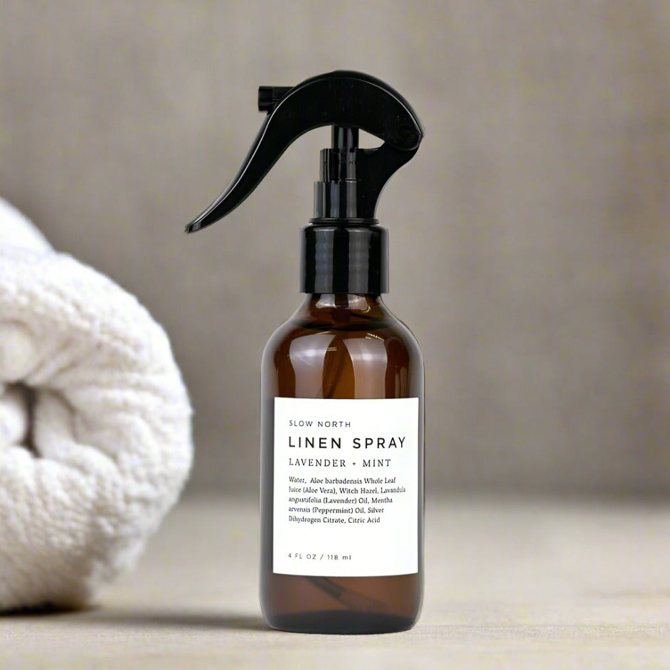 Brown linen spray bottle with black sprayer on a neutral background