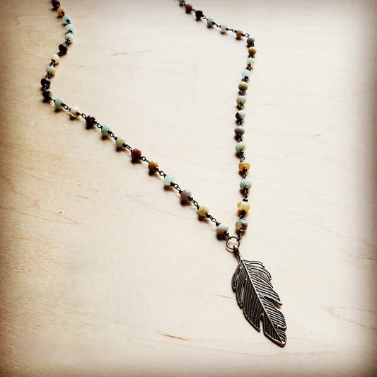 Necklace with a feather pendant on a wooden surface
